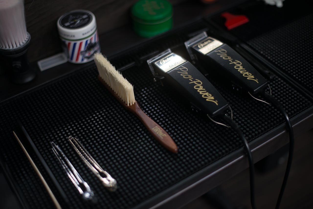 Close-up of hair clippers and grooming tools in a modern barbershop setup.